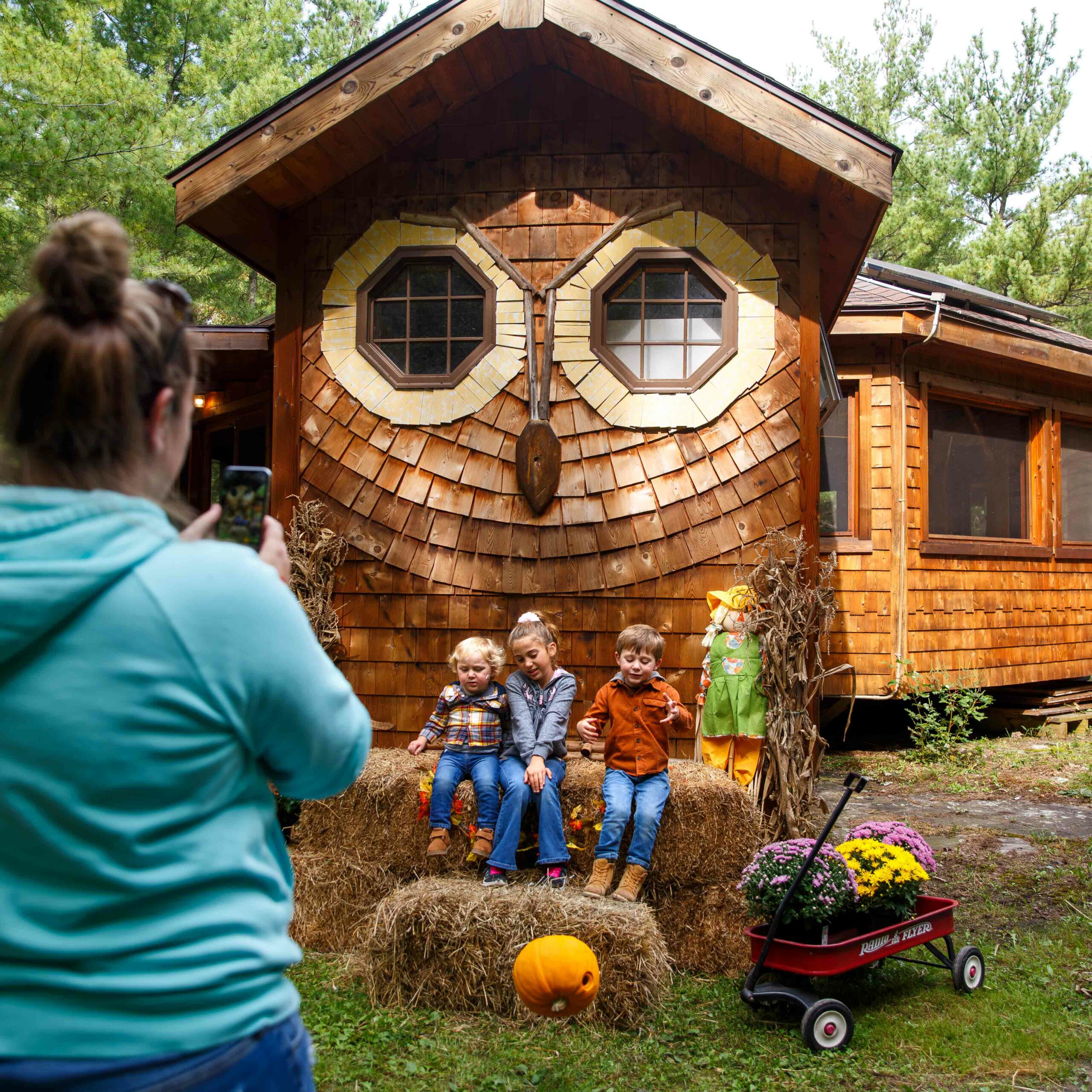 Kids get their photo taken in fall by the owl house