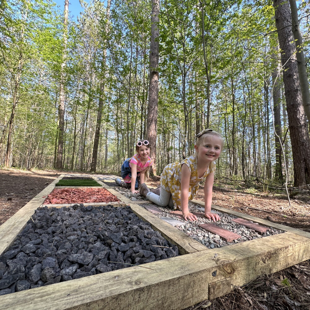 Two girls play on a sensory trail