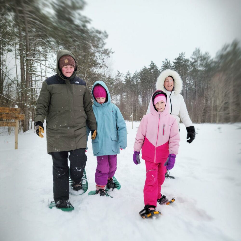 family wearing snowshoes on a trail