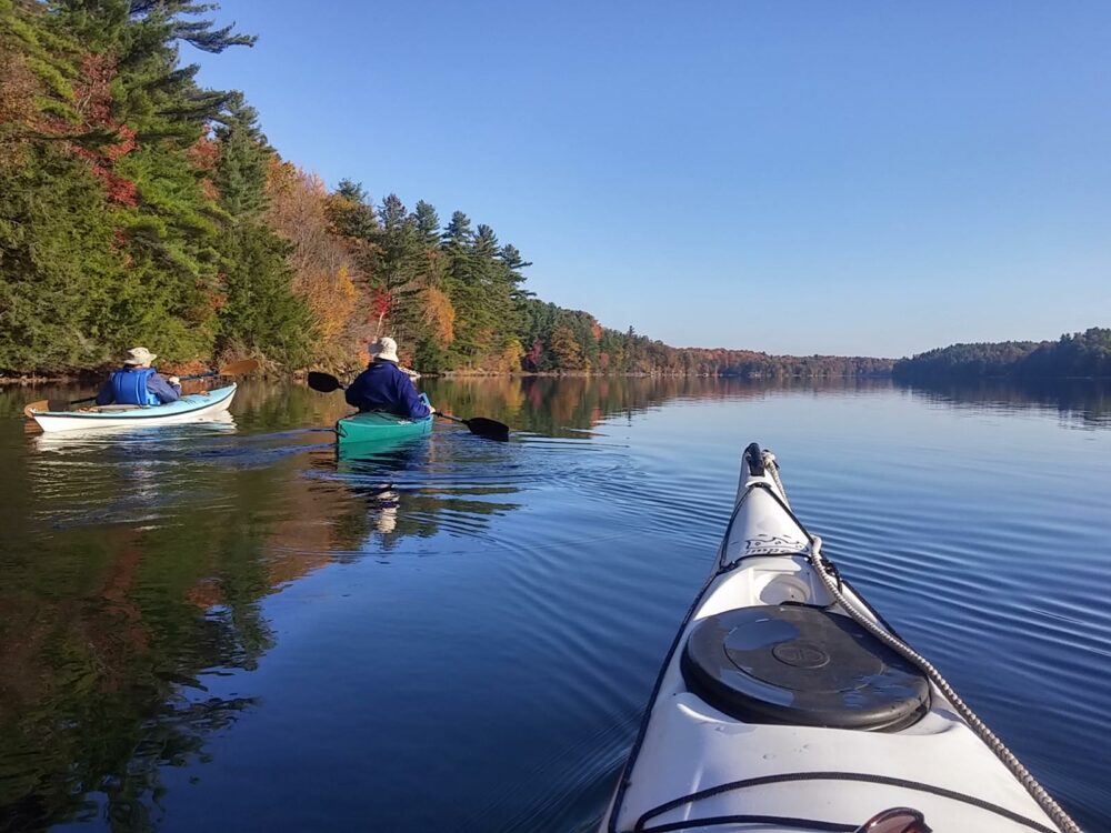 three kayakers paddling