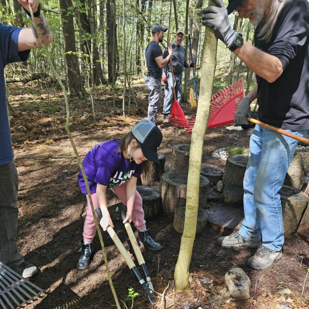 Girl cutting branches in woods for stewardship day