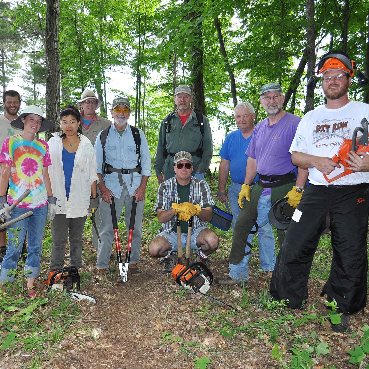 a crew of volunteers with chainsaws and loppers